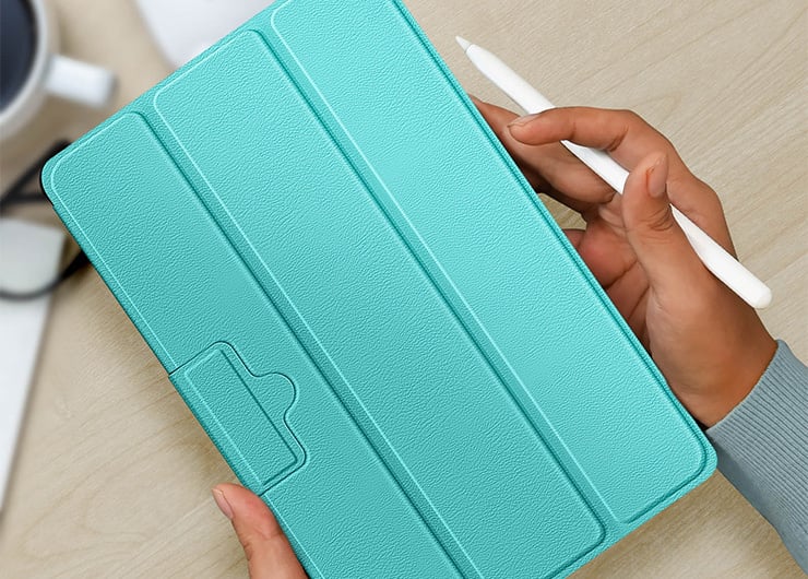 Une tablette dans un étui turquoise, qui est tenue par deux mains