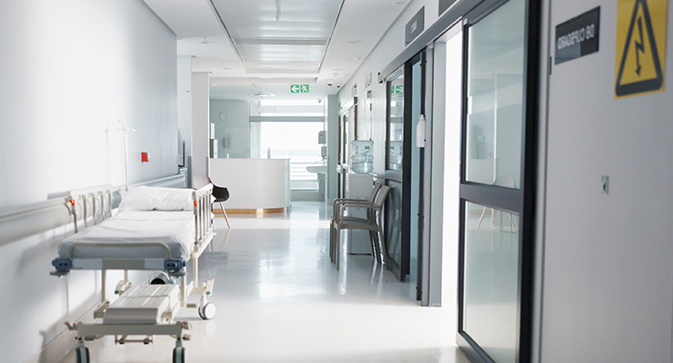 Couloir vide avec lit pour les soins médicaux, y compris la signalisation pour le risque d'électrocution, les urgences et le hall d'entrée 