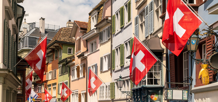 Ruelle d’une vieille ville suisse ornée de nombreux drapeaux suisses pour célébrer la fête nationale du 1er août.
