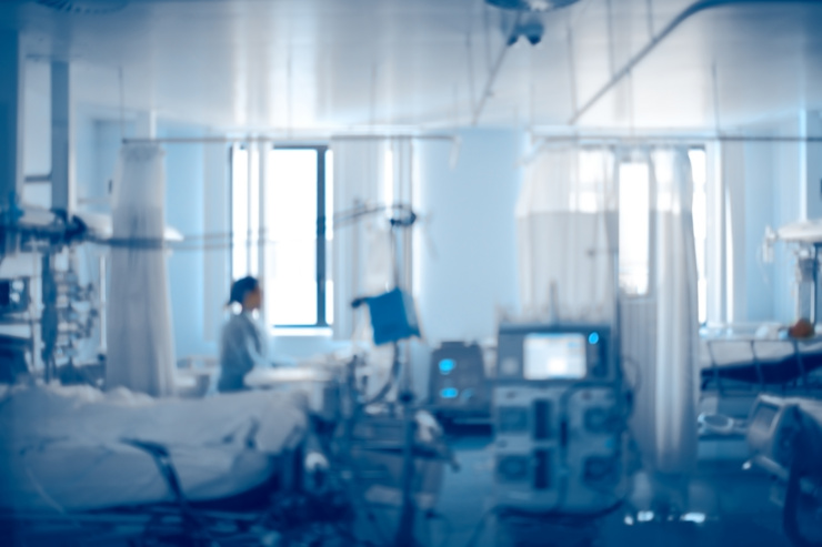 Chambre d’hôpital avec divers équipements médicaux et plusieurs lits.