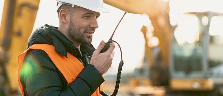 Chef de chantier tenant un émetteur radio dans la main