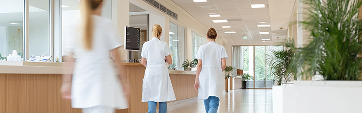 Mouvement flou dans un couloir d'hôpital où marchent des médecins en uniforme