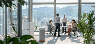 Bureau doté de baies vitrées offrant une vue sur la ville : un purificateur d'air et des plantes d'intérieur garantissent un climat intérieur optimal