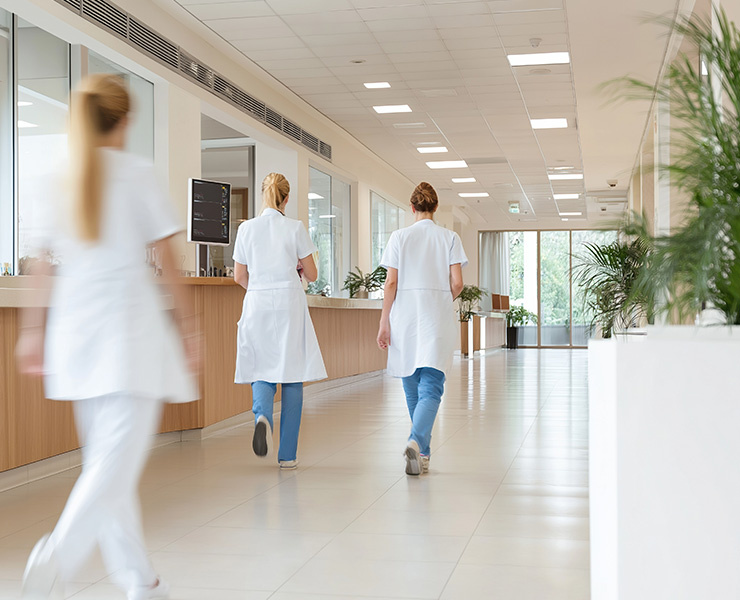 Mouvement flou dans un couloir d'hôpital où marchent des médecins en uniforme