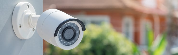 Caméra de surveillance extérieure fixée au mur d’une maison pour sécuriser le jardin.