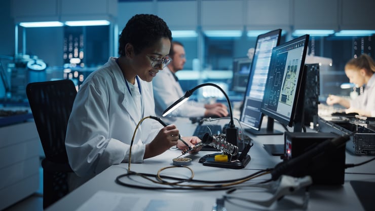 Ingénieure électricienne effectuant des travaux de soudure sur un circuit imprimé miniaturisé - Simulation ESD