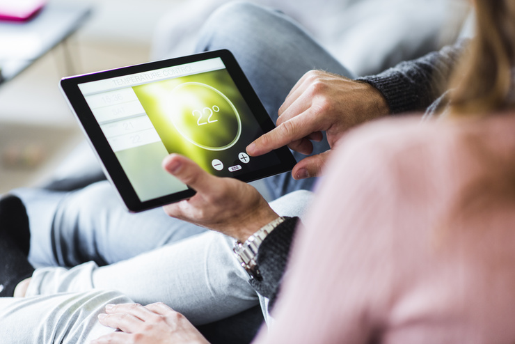 Une personne contrôle l'état du climat intérieur sur la tablette