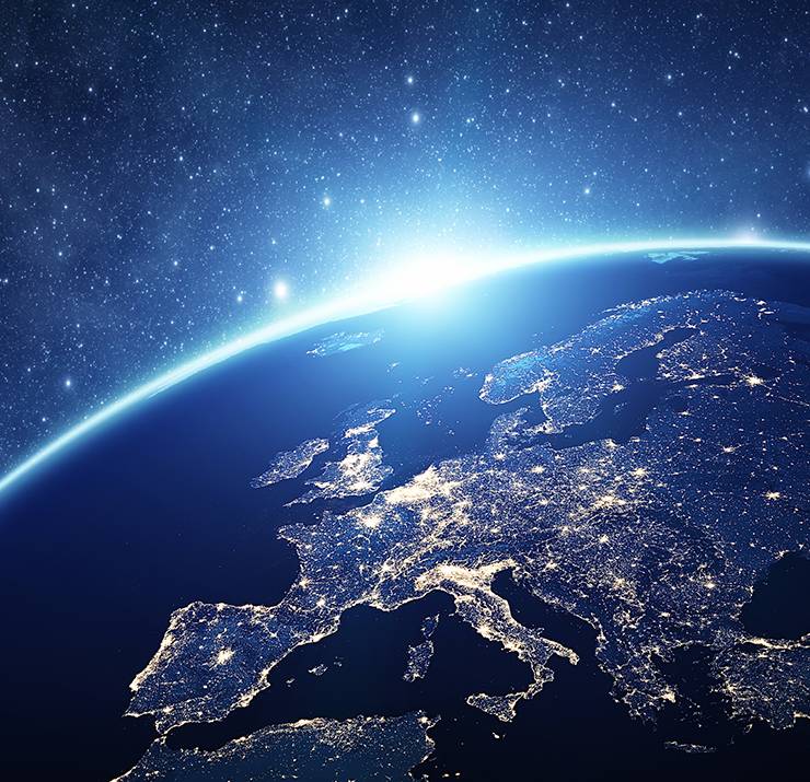 Vue satellite de l'Europe de nuit avec des villes illuminées.