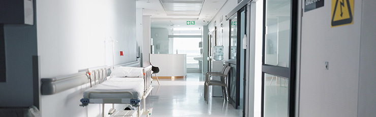 Couloir vide avec lit pour les soins médicaux, y compris la signalisation pour le risque d'électrocution, les urgences et le hall d'entrée 