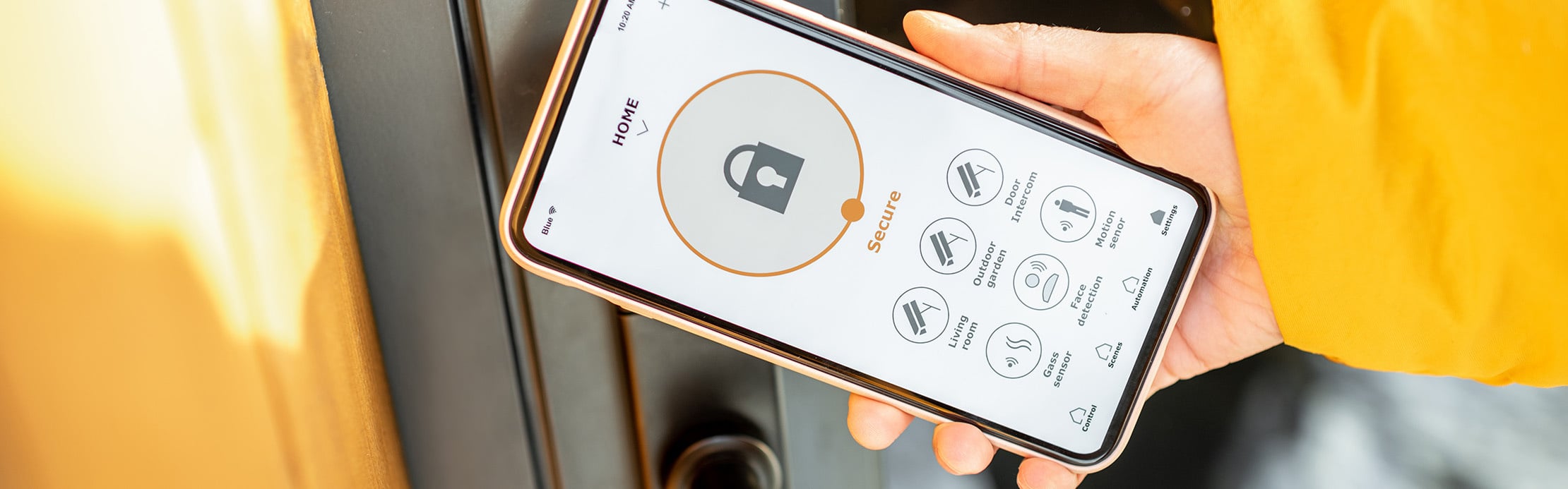 Une personne contrôle un système de sécurité intelligent pour la maison via une application sur son smartphone.