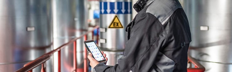 Technicien avec un téléphone portable dans une installation