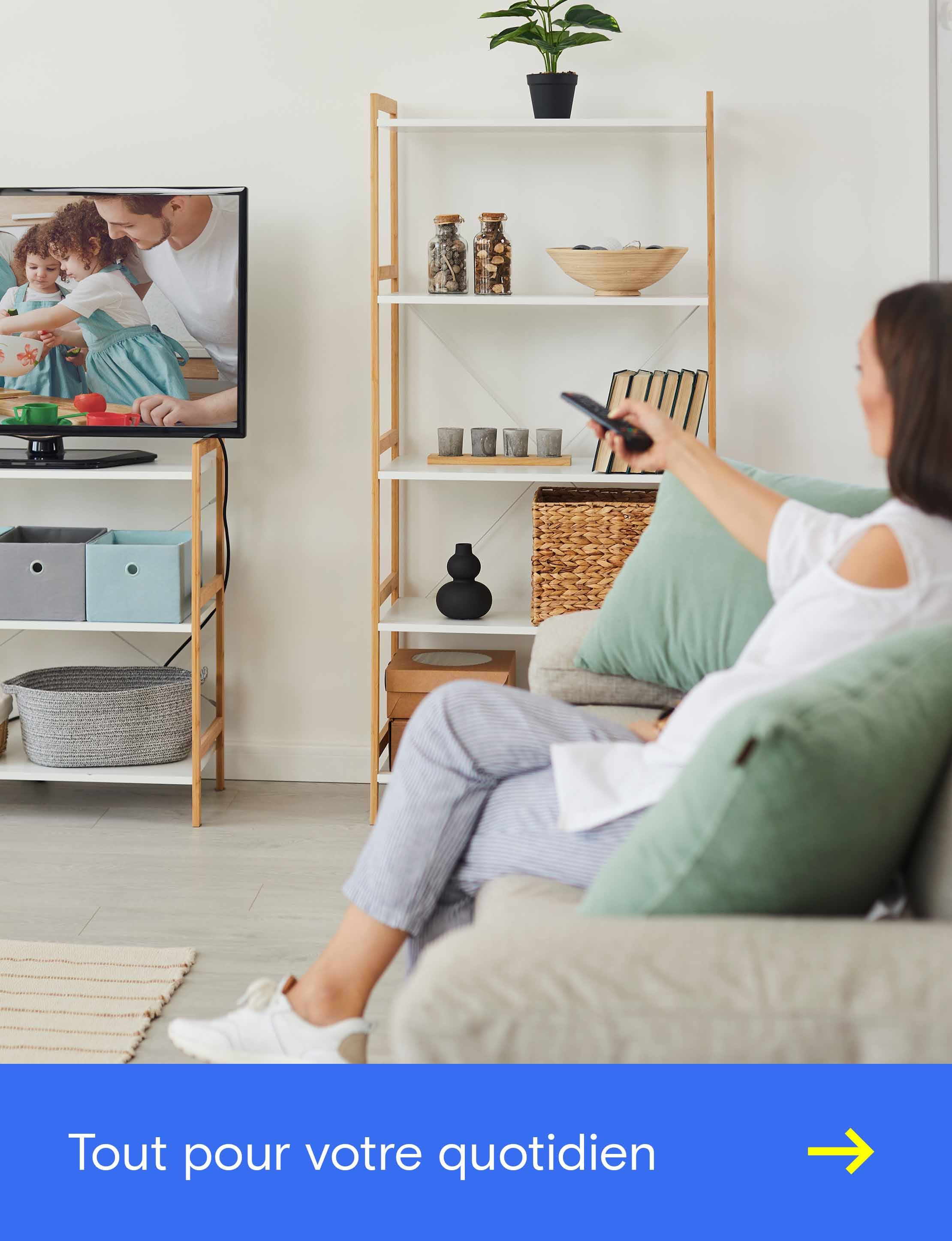 Visuel promotionnel montrant une personne regardant la télévision dans son salon, accompagné du texte « Des solutions technologiques adaptées à vos besoins » pour des solutions personnalisées dédiées au divertissement à domicile et à l’électronique grand public.