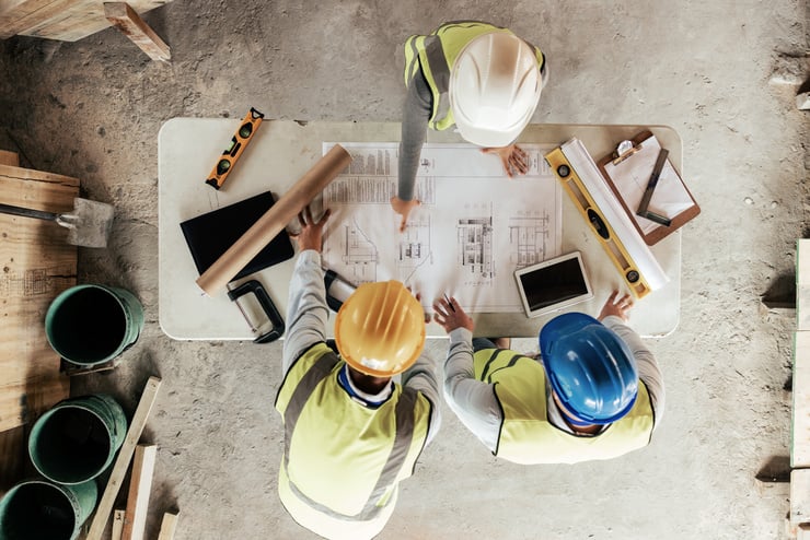 Hommes étudiant le plan du chantier