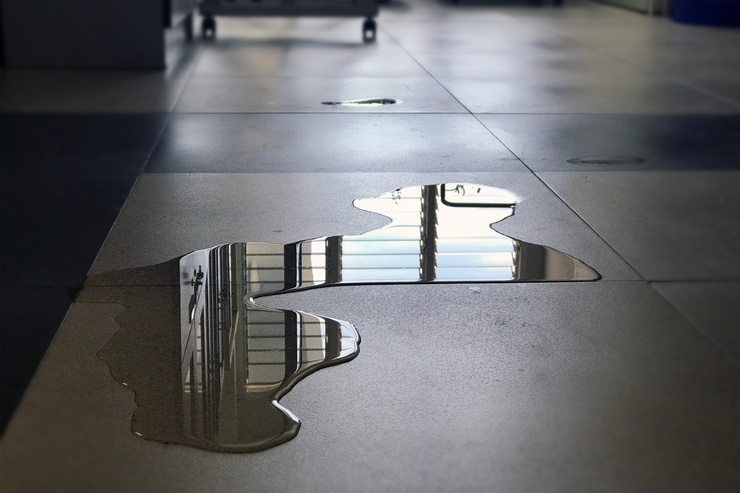 Flaque d'eau sur un sol glissant suite à une fuite