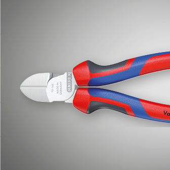 Krupni plan prikazuje Knipex bočne rezače s crvenim i plavim ručkama na sivoj pozadini.