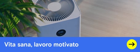 Un purificatore d'aria bianco si trova su un pavimento di legno, con uno striscione che pubblicizza una vita più sana e una maggiore motivazione.