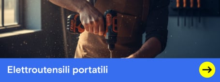 Un uomo con un grembiule e occhiali di sicurezza fora un telaio di legno con un trapano avvitatore elettrico in un'officina.