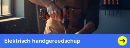 Een man in een schort en veiligheidsbril boort met een elektrische schroefboormachine in een houten frame in een werkplaats.