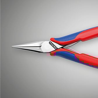 Een close-up toont een tang met puntige bek en rode en blauwe handvatten tegen een grijze achtergrond.