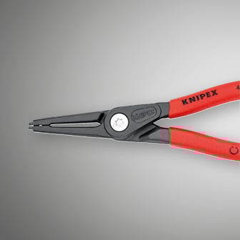 De afbeelding toont een close-up van een Knipex-borgringtang met rode handgrepen en grijze bekken tegen een wazige grijze achtergrond.